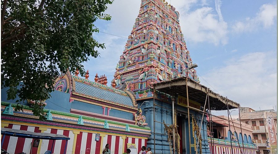 Painted gopuram tower of a South Indian Vaishnava temple against a blue sky